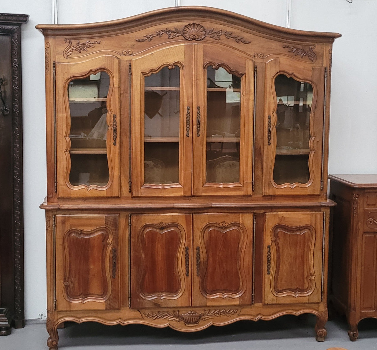 Magnificent French Walnut two-body four door display cabinet. Heaps of storage space with four glass doors at the top with shelves and four solid doors below also with shelving. It has been sourced from France and comes with a key for each door and all are lockable. In good original detailed condition.