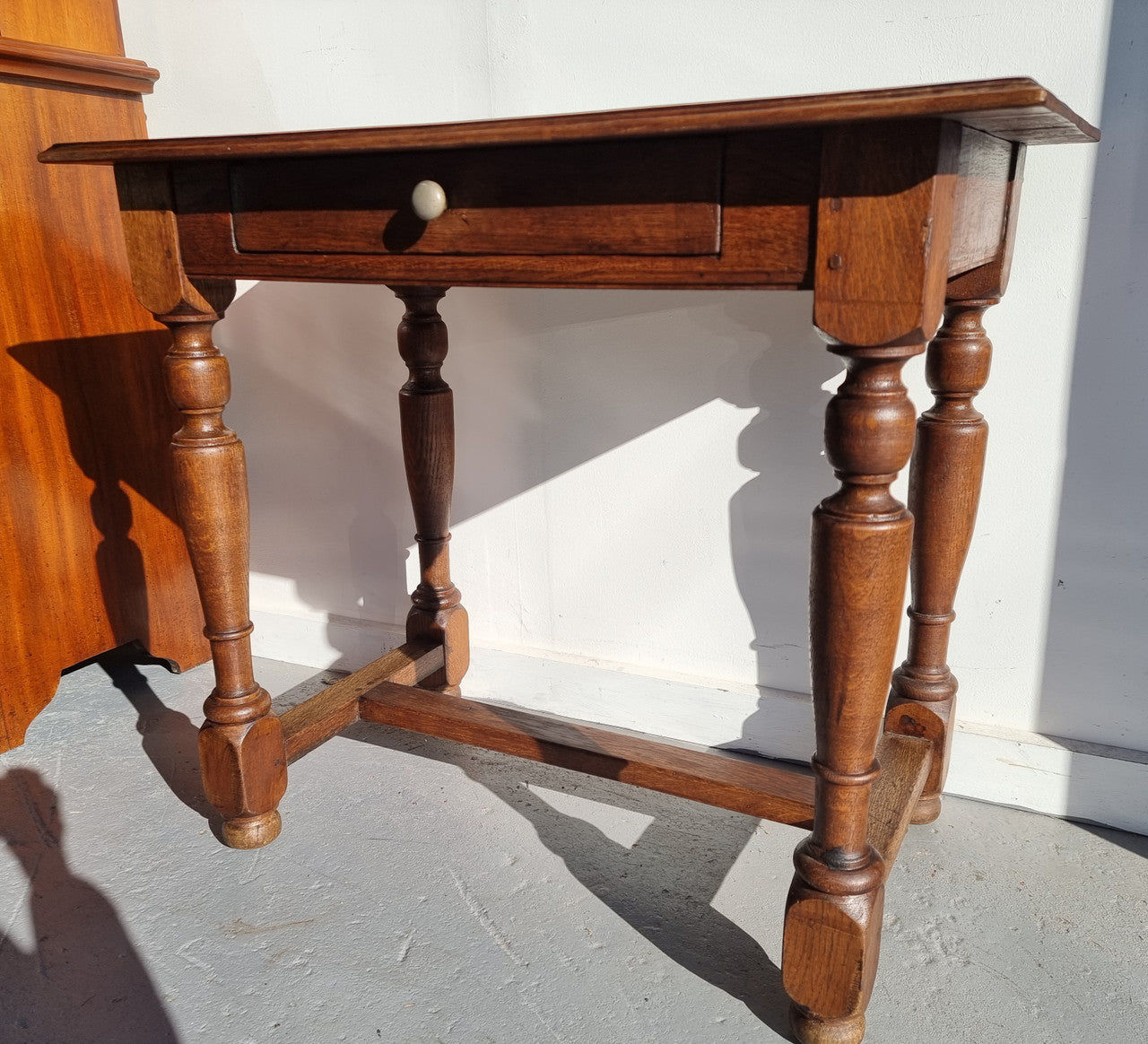 Rustic French Oak side table or desk with single drawer and turned legs. In good original detailed condition.