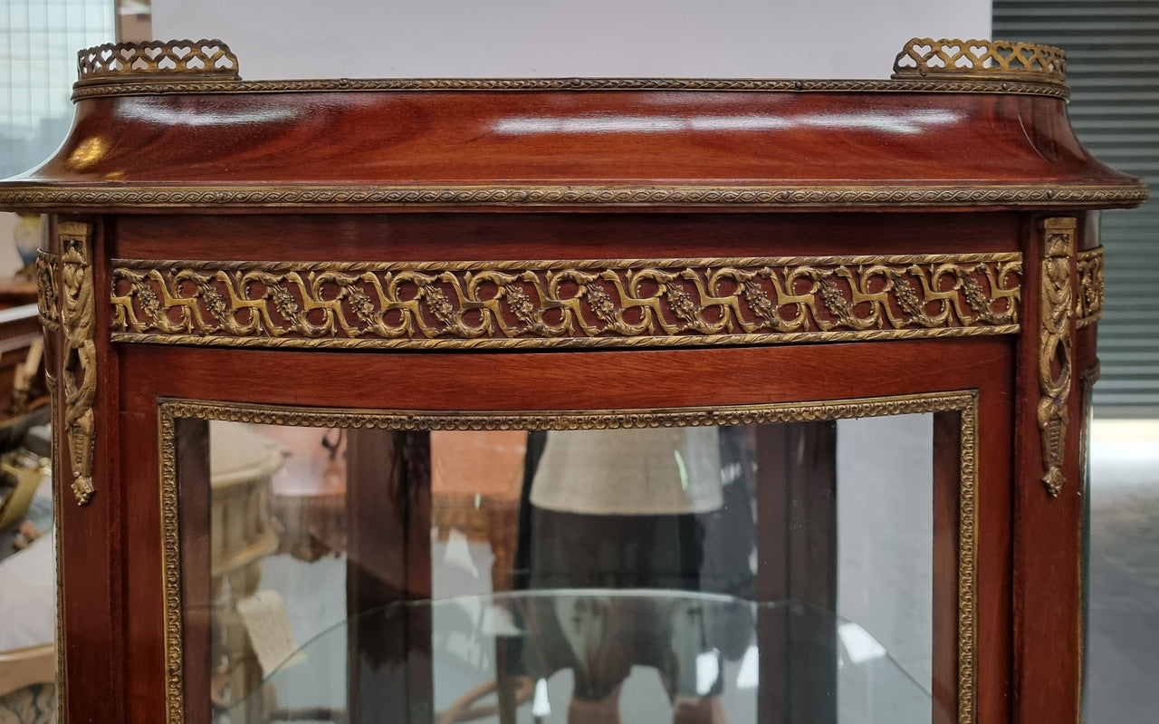 Beautiful French Louis XV style vitrine/ display cabinet with curved glass, gilt mounts, mirrored back and two glass shelves for your displays . It is in good original detailed condition.
