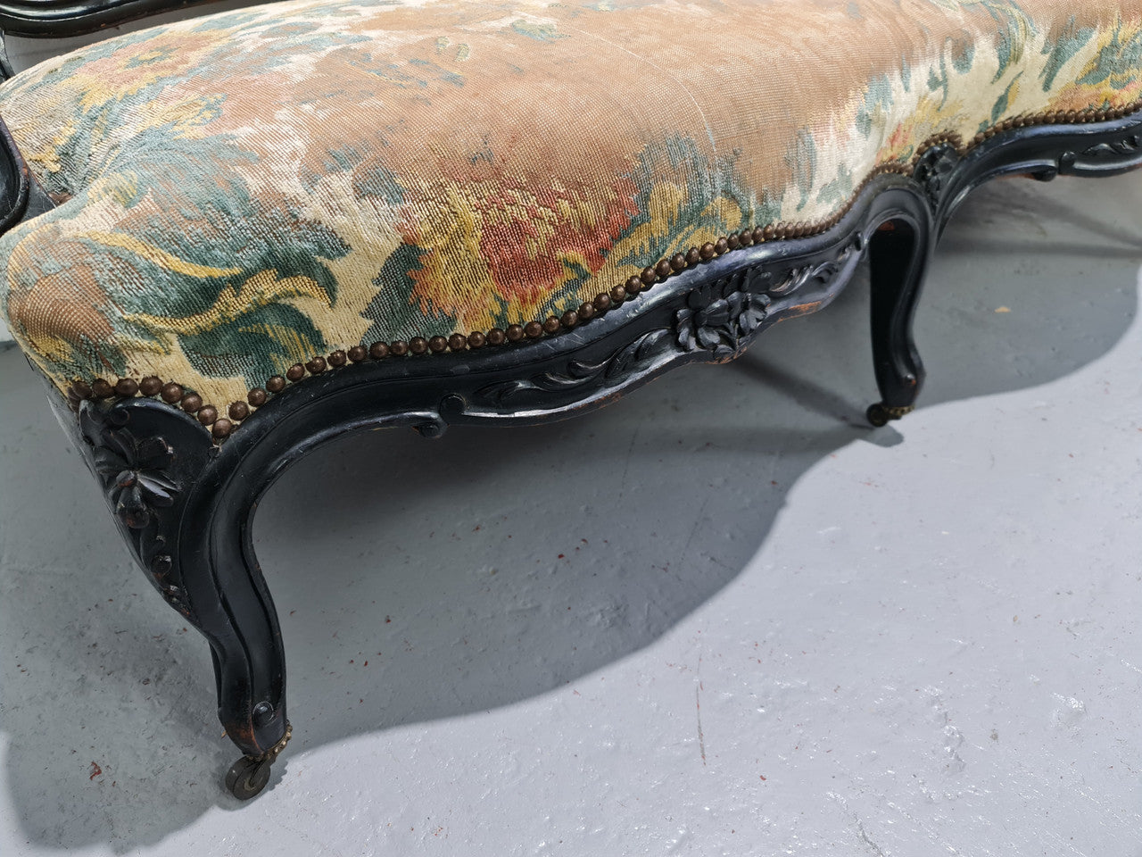 A Substantial Antique 19th Century Louis XV style ebonized serpentine front settee. The fabric is in used condition showing use and could be used as is or reupholster.