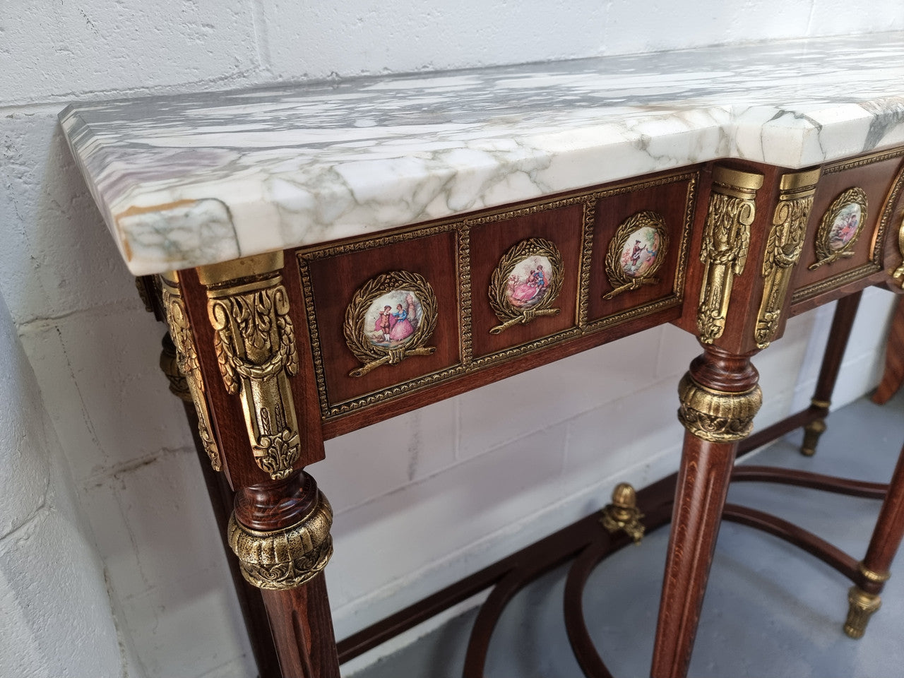 Vintage Mahogany marble top console table with matching mirror. Both with inset limoge panels surrounded by gilt brass. Highly decorative and in good original detailed condition. Circa 1950.