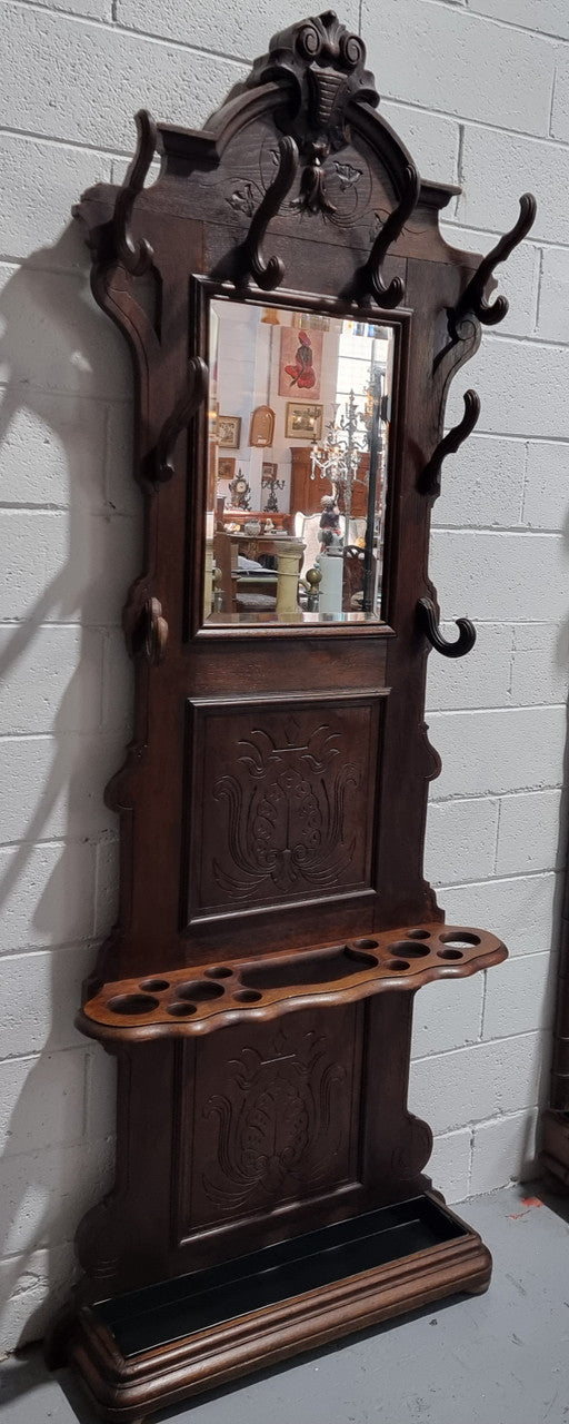 A beautiful Henry II style narrow French Oak hall stand. It has beautiful decorative carvings as well as 8 wooden hooks and storage for umbrellas and walking sticks. In good original detailed condition.