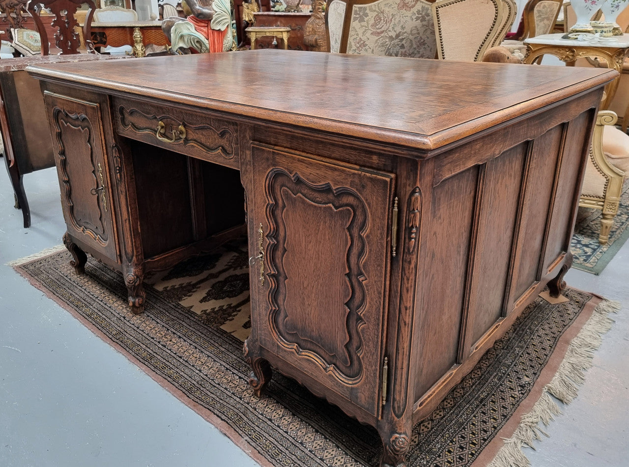 Fabulous Louis XV style French Oak beautifully carved full partners desk. Both sides have a functioning drawer in the middle and two cupboards either side. On both sides one cupboard door opens up to four smaller internal drawers. Plenty of storage space and a large top surface to work on. It is in good original detailed condition.