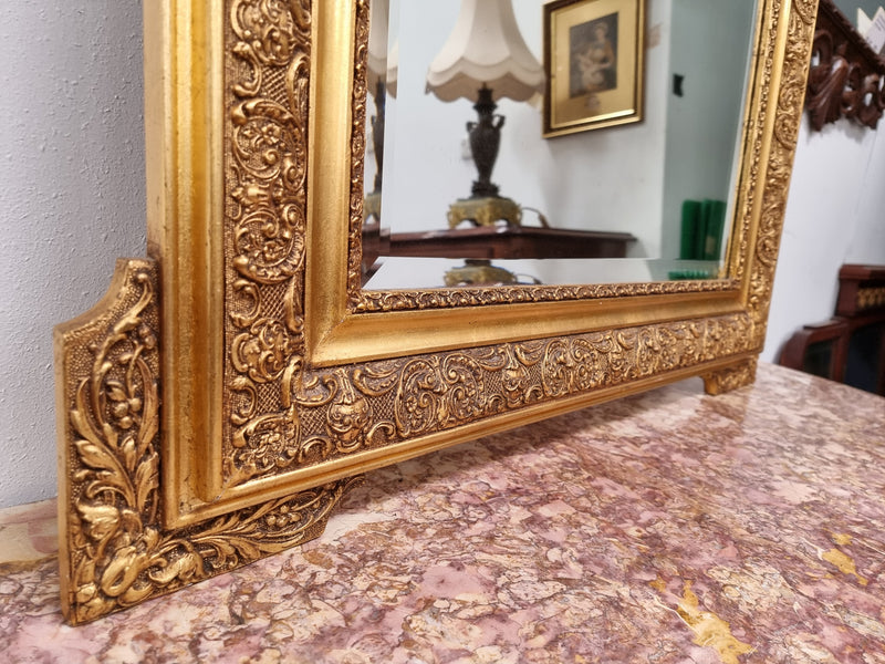 French ornate gilt decorated and floral bevelled mirror. It has been sourced from France and it is in good original condition.