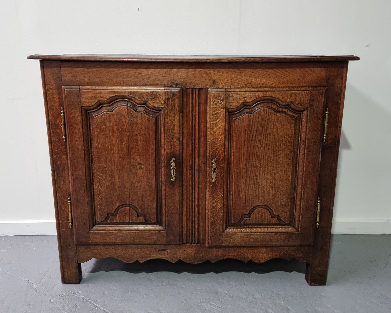 A charming French Oak early 18th Century two door sideboard. Plenty of storage space with two fixed shelves either side. It is in good original detailed condition for its age and comes with a working key and working locks.