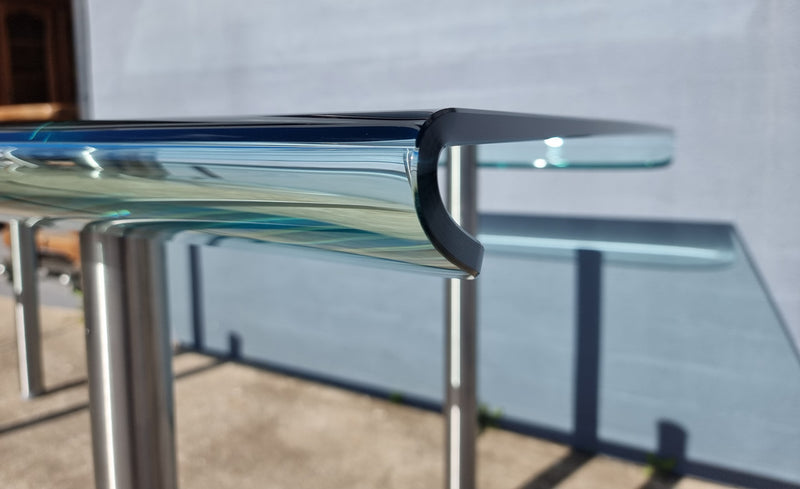 Striking and distinctive Vintage FIAM Italia Designer curved edge glass desk. FIAM was founded in 1973 by Vittorio Livio and has become synonymous with glass culture in Italy and the World. FIAM is still manufacturing today, in collaboration with various Designers, and has won numerous awards and is represented in various international museums. 
Condition: Evidence of use with minor scratches to the surface and a small chip that has been repaired. Overall, in very good condition with one repaired chip to t