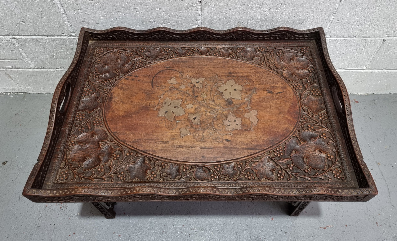 Anglo Indian folding occasional table with lift-up tray top. The tray has brass inlay and ornate carvings. The bottom of the table folds down and it is in good original condition.