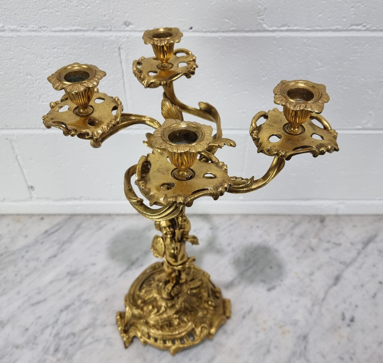 A pretty 19th Century French gilt bronze candelabra featuring a cherub. In good condition. Circa 1880.