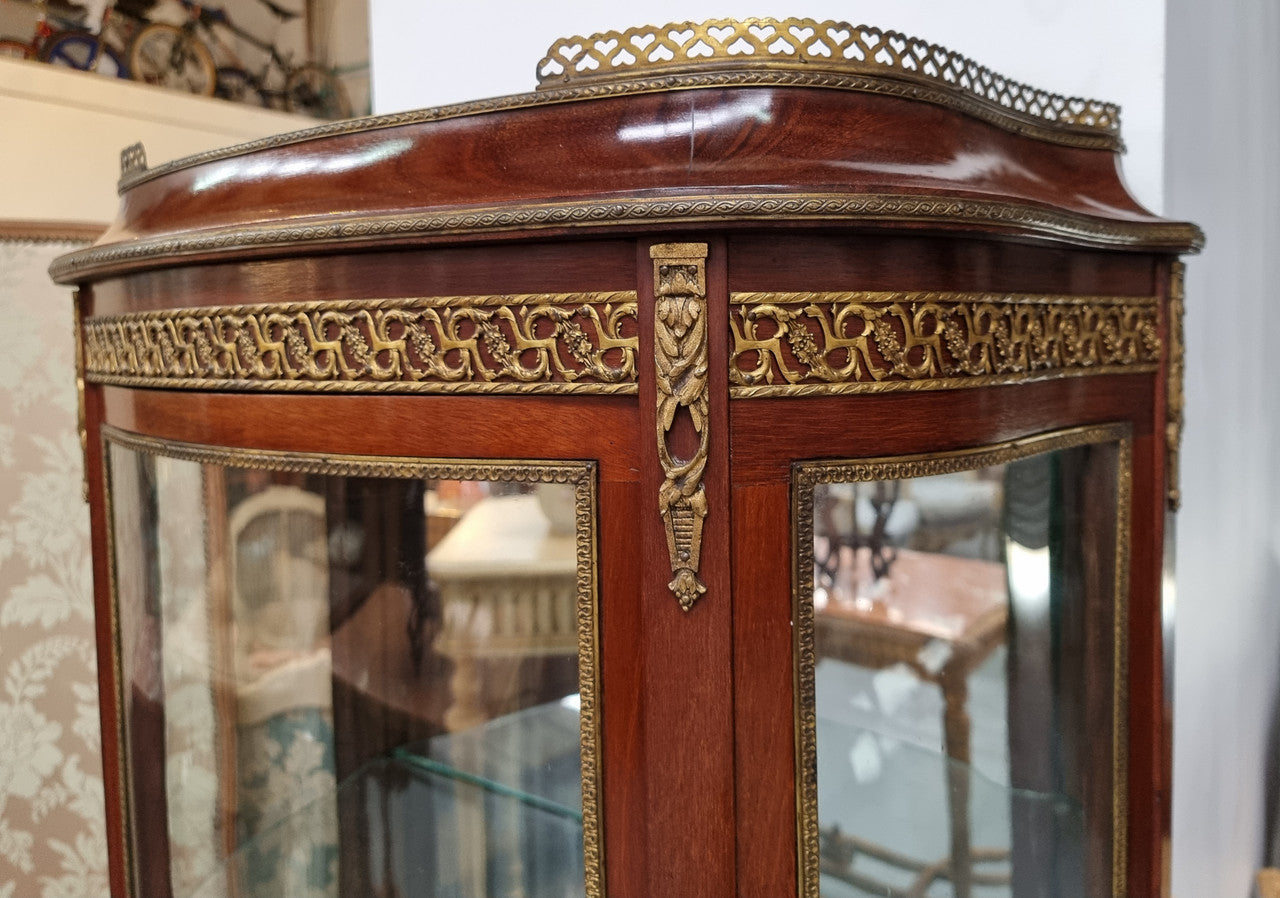 Beautiful French Louis XV style vitrine/ display cabinet with curved glass, gilt mounts, mirrored back and two glass shelves for your displays . It is in good original detailed condition.