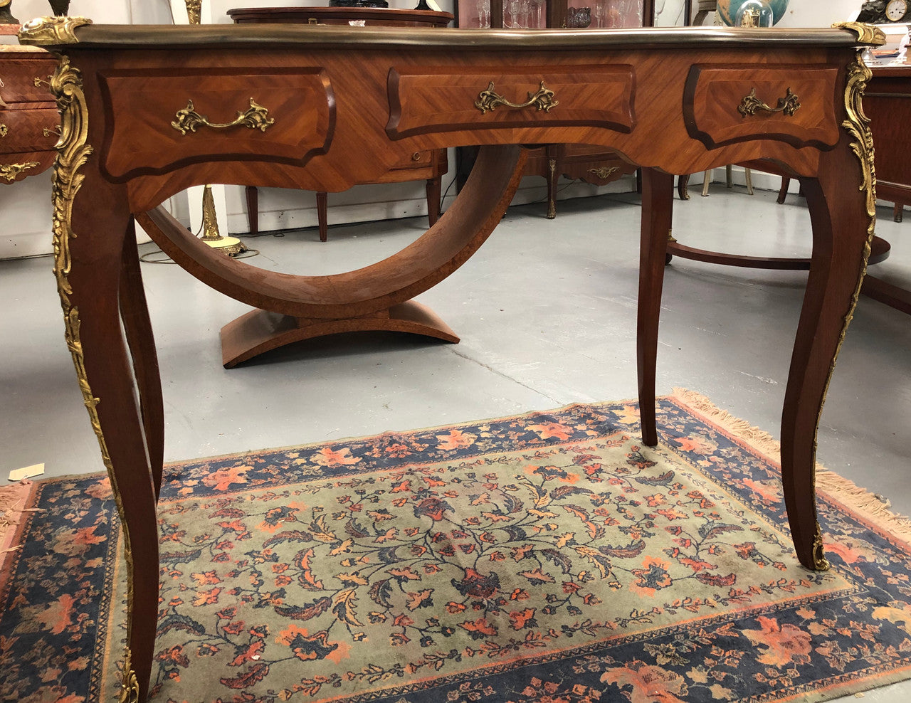 An impressive French Walnut petite Bureau Plat with superb ormolu mounts, original tooled leather top with loads of character and drawers for storage. It is in very good original detailed condition.