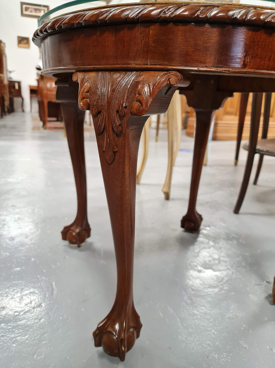A beautiful round Mahogany Chippendale style coffee table with a glass top. In good original detailed condition.