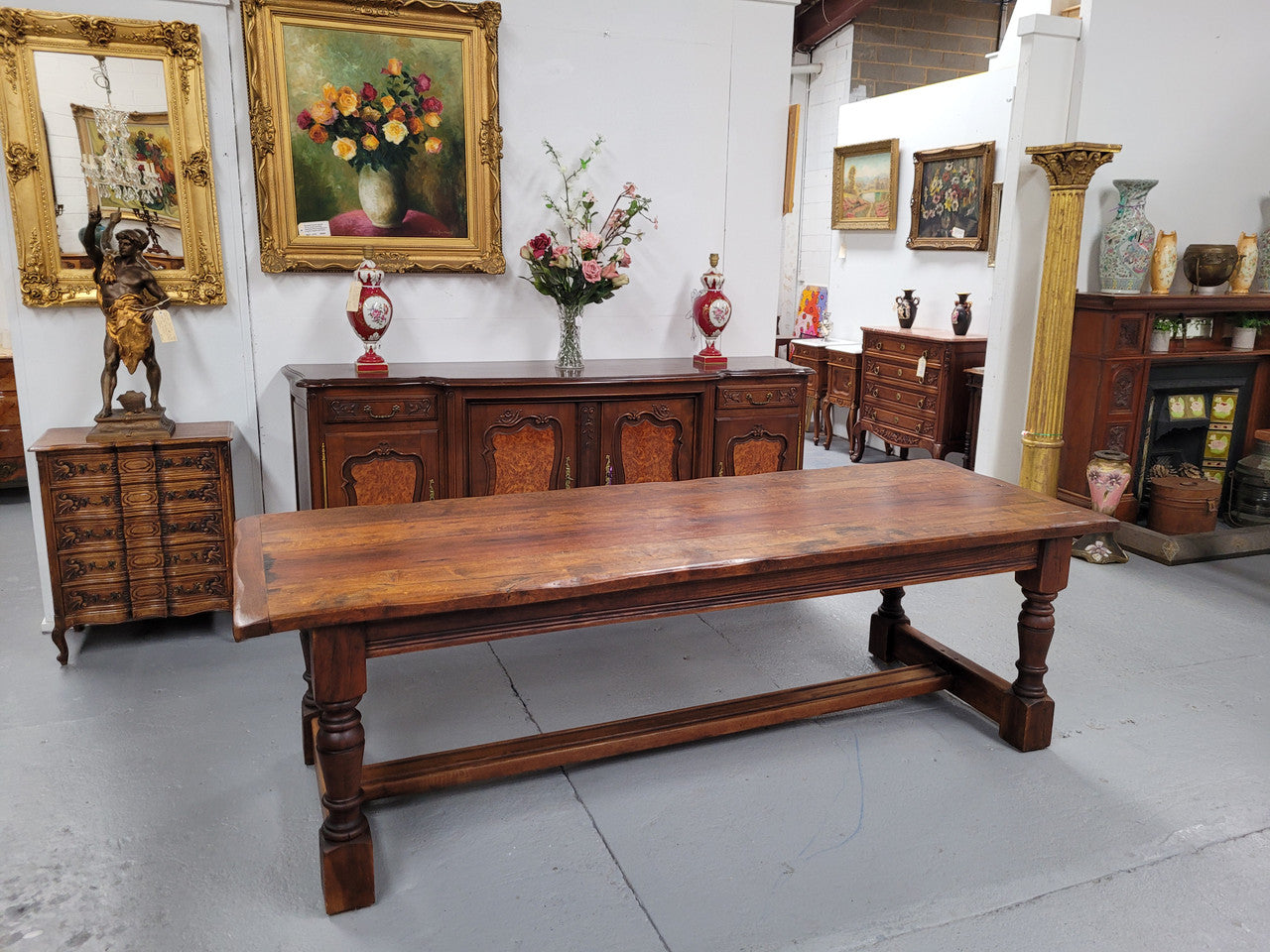 Charming solid rustic Oak stretcher base Farmhouse table. The table is circa 1950's and was custom made using reclaimed oak. It comfortable sits eight and could seat 10. It is in good original detailed condition.