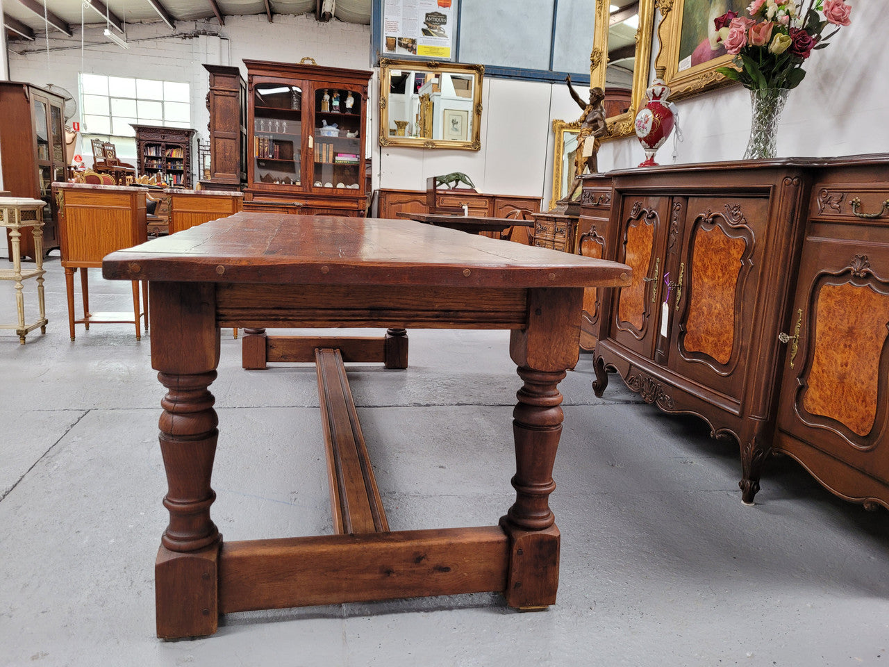 Charming solid rustic Oak stretcher base Farmhouse table. The table is circa 1950's and was custom made using reclaimed oak. It comfortable sits eight and could seat 10. It is in good original detailed condition.
