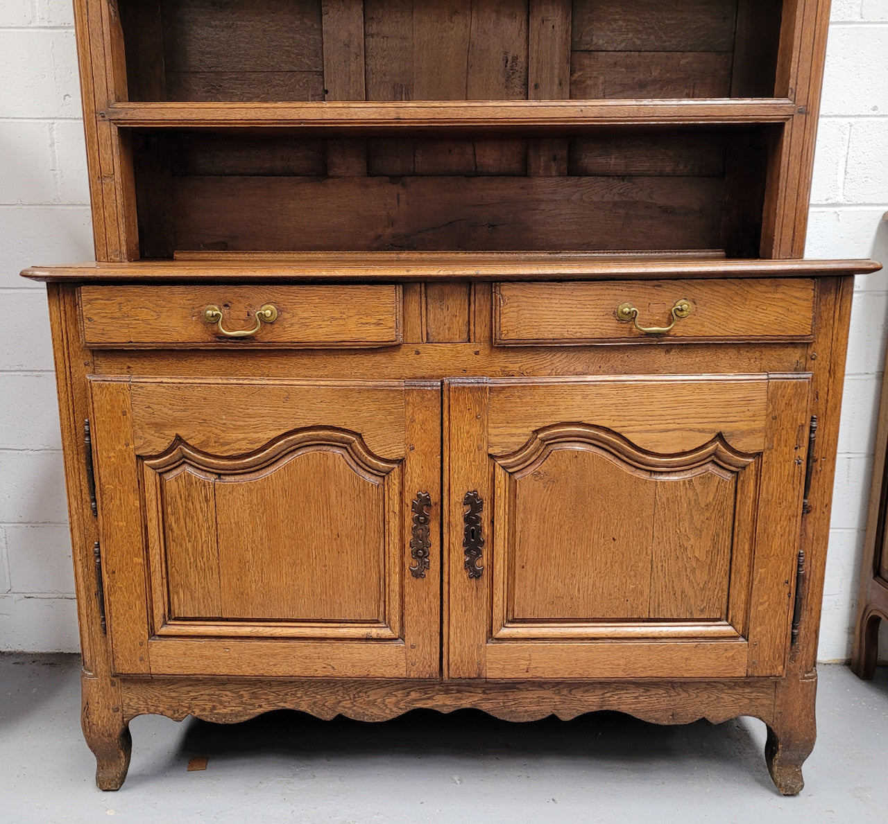 Charming 18th Century French Oak Vaisselier / kitchen dresser with two cupboard doors and three open shelves at the top. Sourced from France and in good original detailed condition.