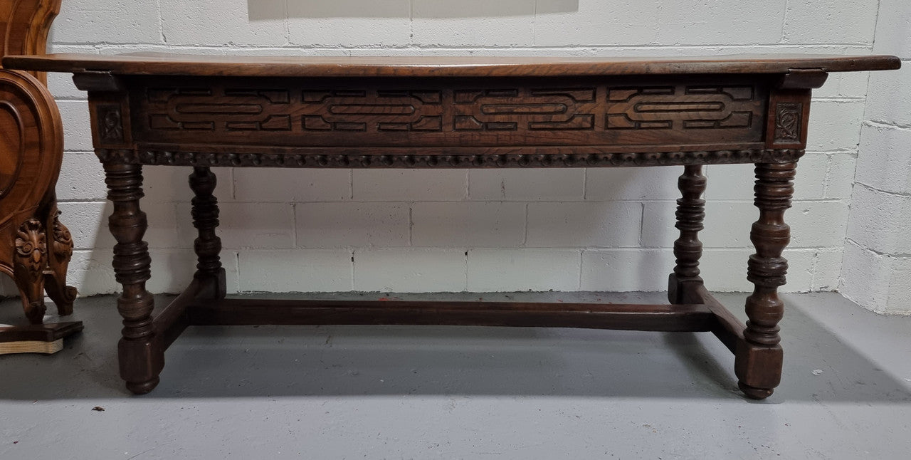 Rare and Charming 17th Century Spanish Walnut serving / side table. It has an incredible one piece walnut top with amazing character and colour. The base displays the original patina aswell as three drawers with carving and remnants of original locks. Superbly turned legs terminating on a stretcher base. Could be used as a large entrance console table, a side table or in a dining area as a serving table. In good original detailed condition especially considering its age.