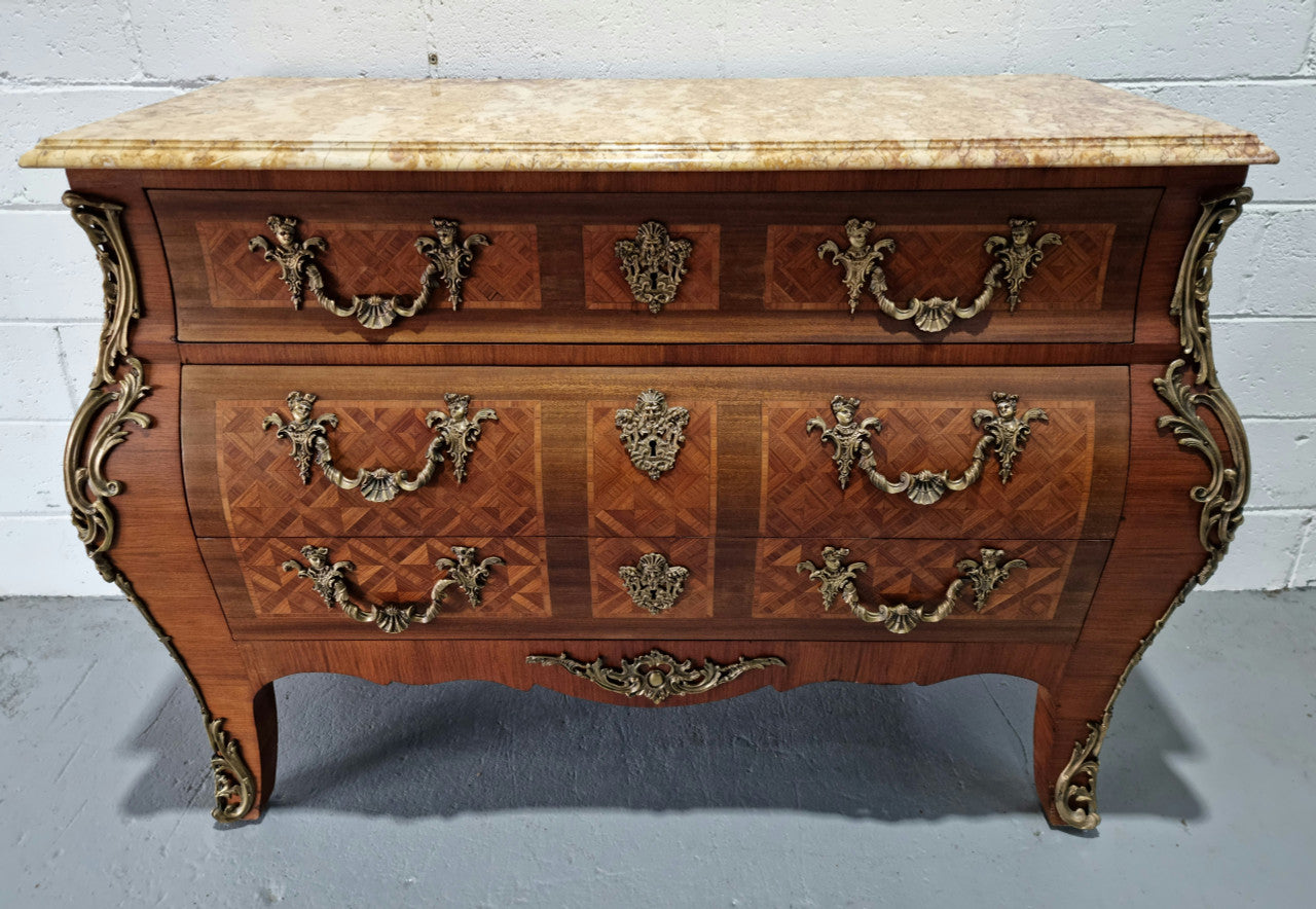 A beautifully inlaid parquetry three drawer commode with a lovely marble top, and decorative ormolu mounts. In good original detailed condition. Circa 1930