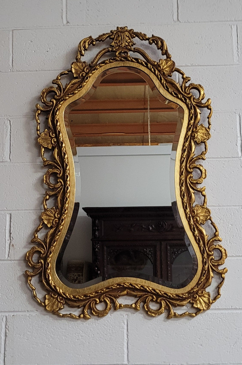 Large Vintage Italian carved wood gilt mirror. It has a beautiful bevelled mirror and has been sourced from France. It is in good original condition.