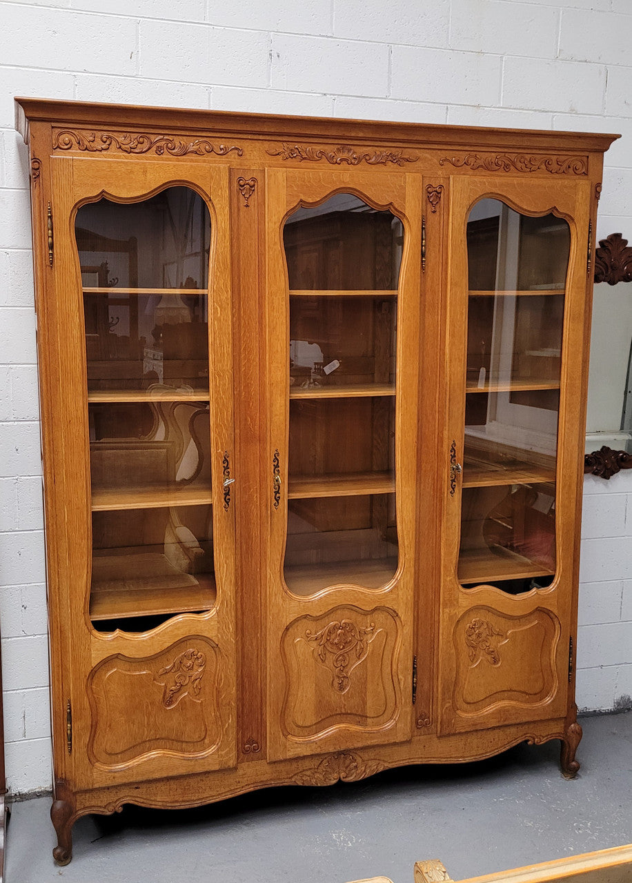 French Louis XV style light Oak three door bookcase with five fixed shelves. It has lovley glass doors and has been sourced from France. Is in good original detailed condition