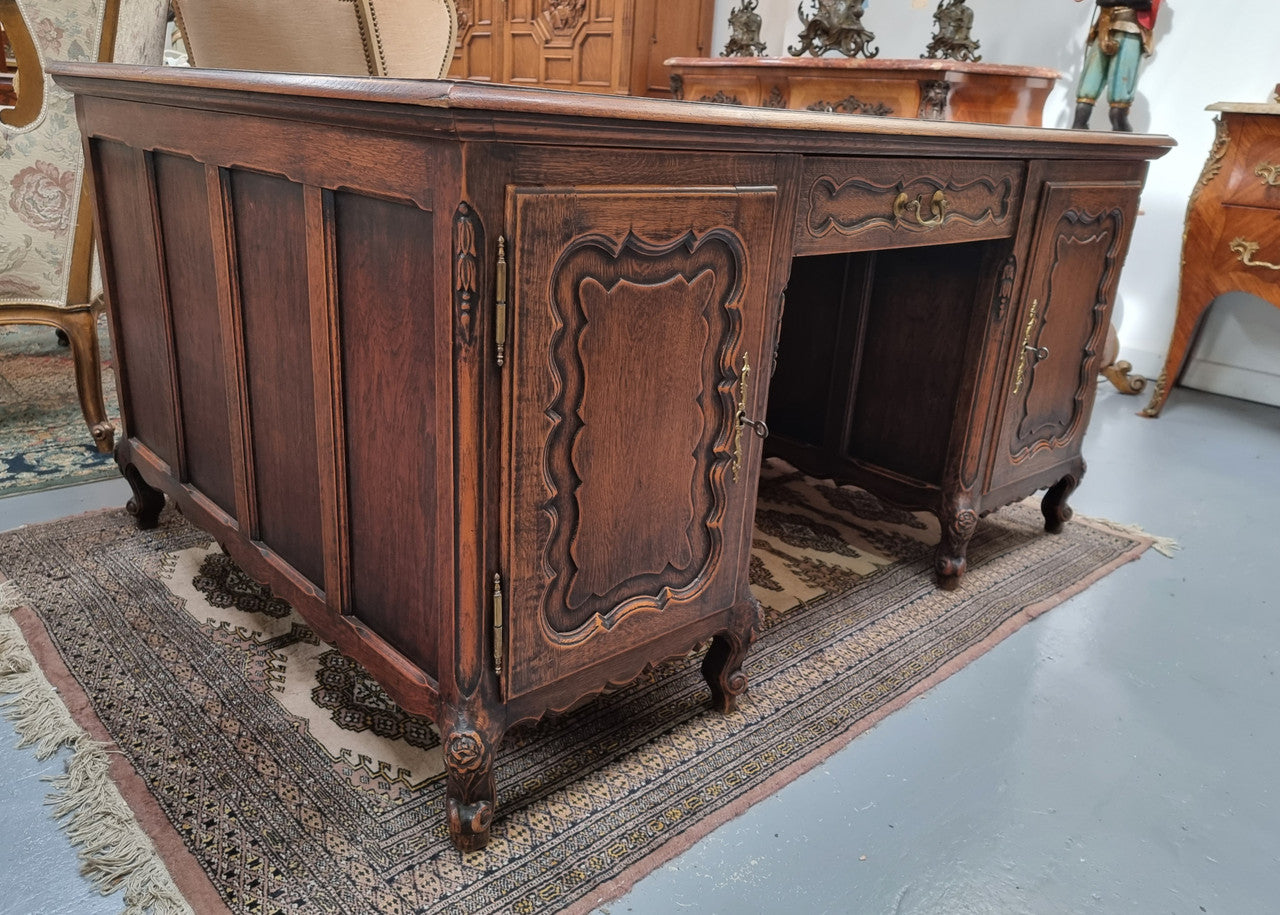 Fabulous Louis XV style French Oak beautifully carved full partners desk. Both sides have a functioning drawer in the middle and two cupboards either side. On both sides one cupboard door opens up to four smaller internal drawers. Plenty of storage space and a large top surface to work on. It is in good original detailed condition.