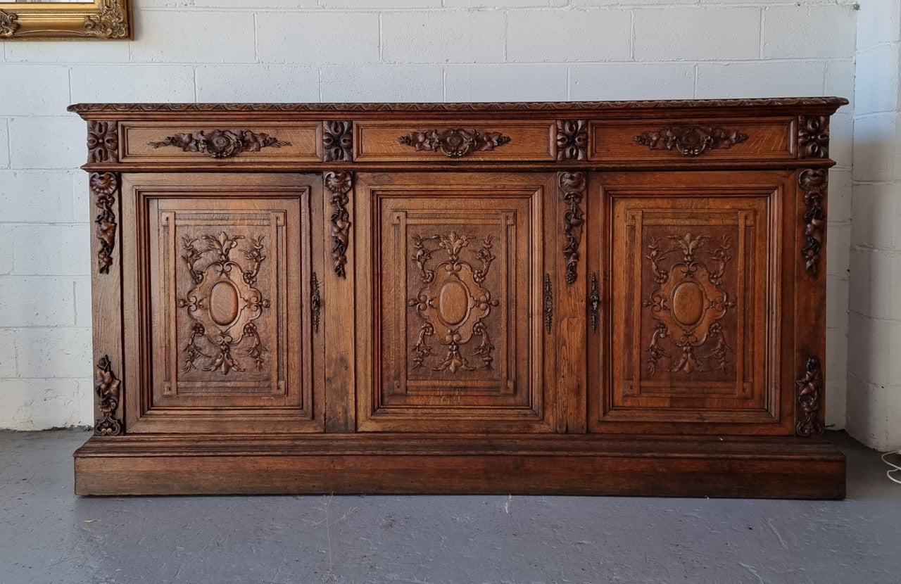 Stunning 19th Century French Oak Renaissance style sideboard base of hard to find dimensions. Amazing detailed carving with three cupboards and three drawers. It is in good original detailed condition.