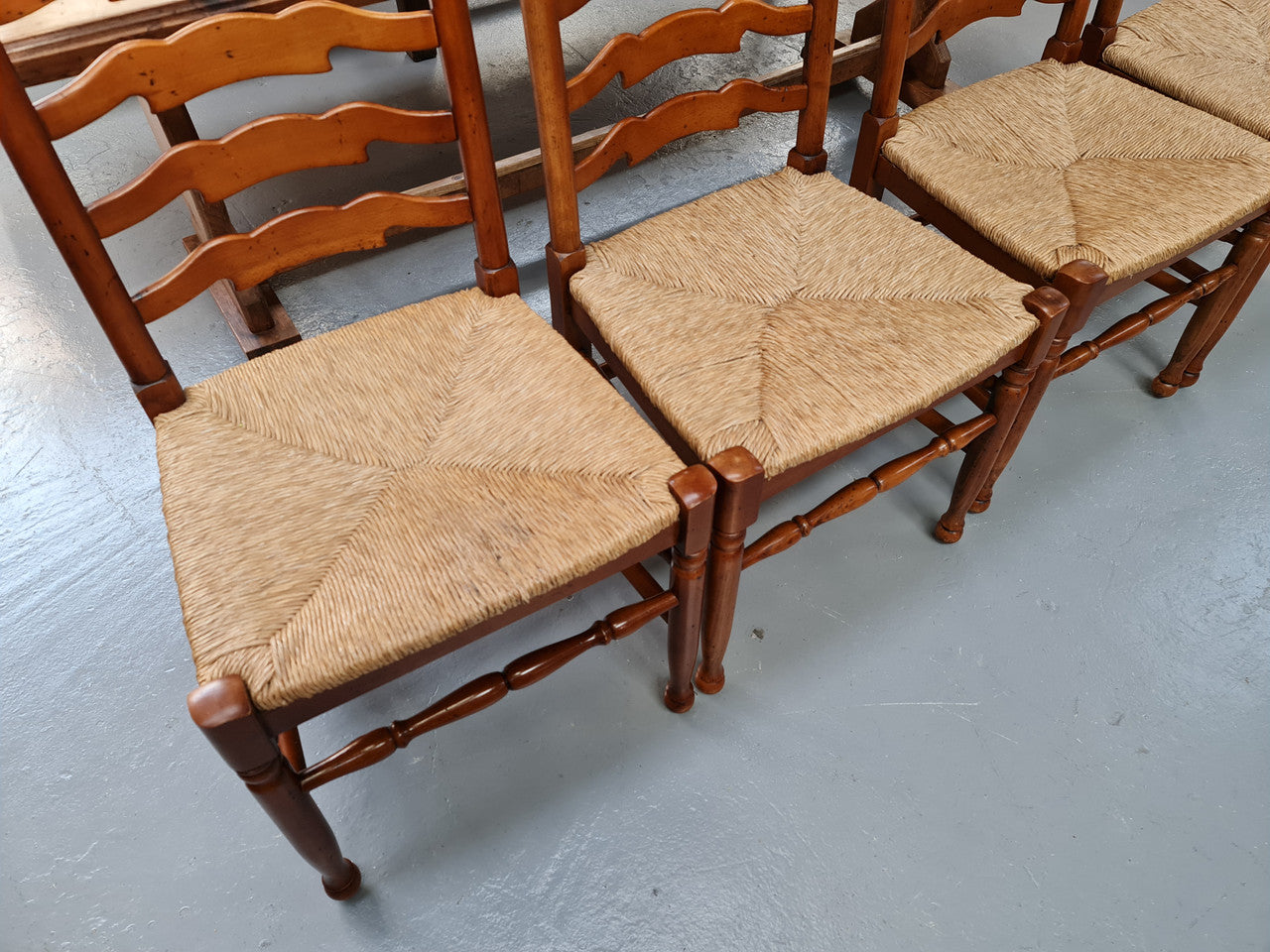 Charming set of eight Cherry Wood ladder back dining chairs. They are in good original detailed condition.