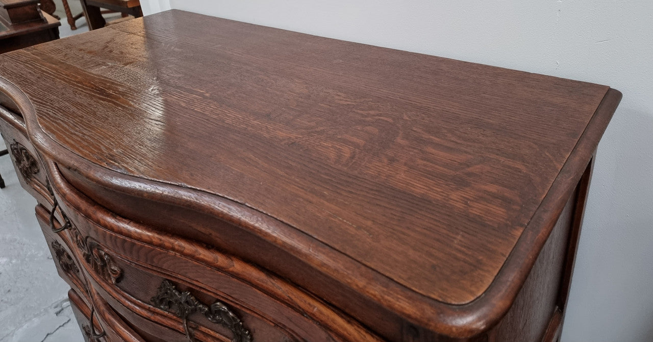 Antique French beautifully carved dark Oak commode with three drawers and ornate handles. It is in good original detailed condition.