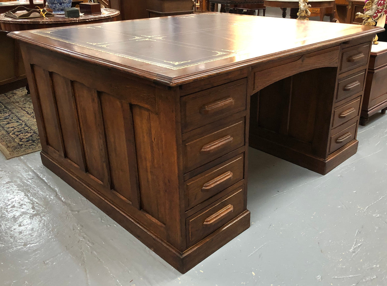 Lovely large English oak partners desk, with a beautiful burgundy tooled leather top. Plenty of storage space, both sides have 9 functioning drawers. It is in very good condition.