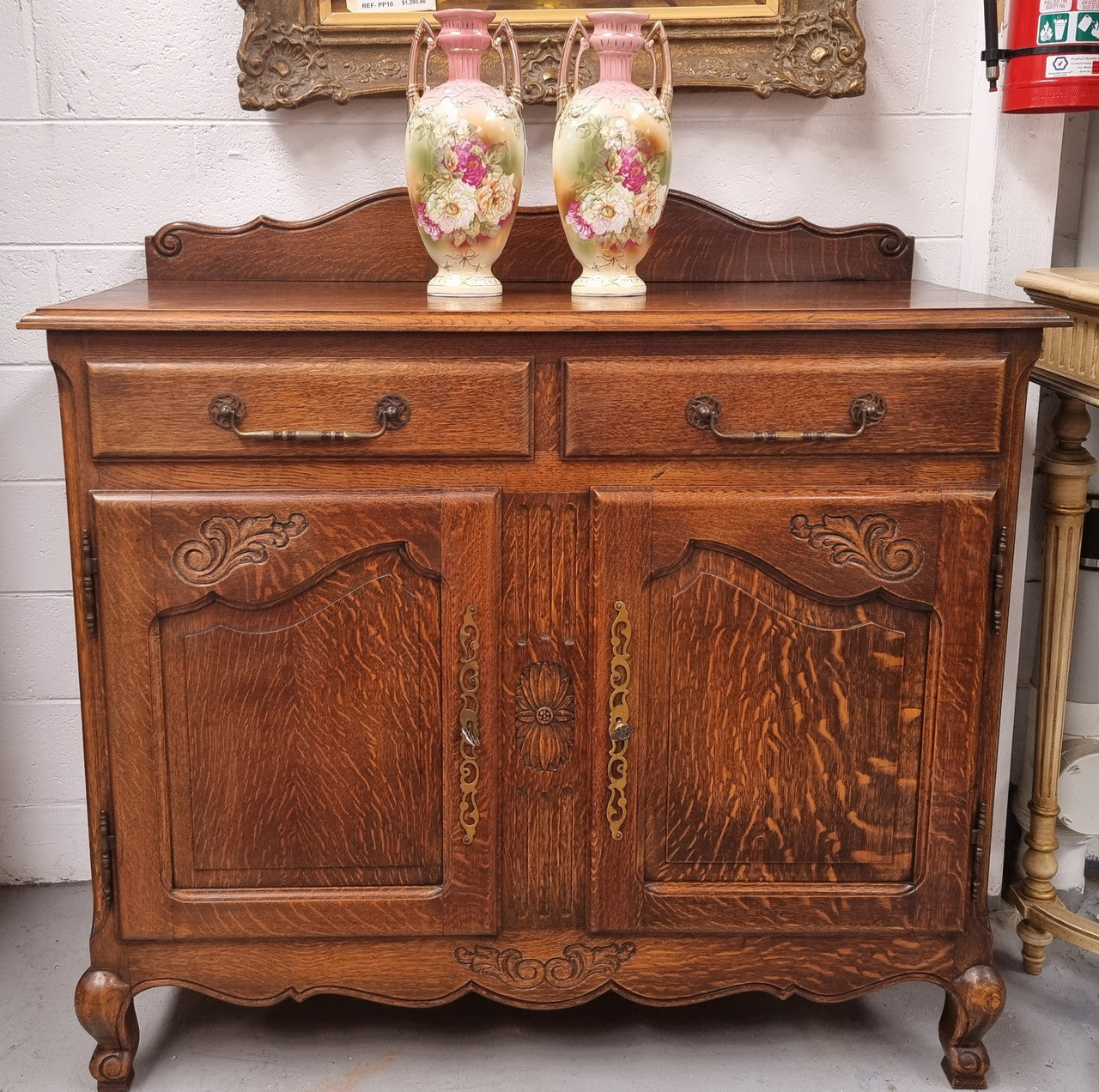 French Louis XV style Oak two door, two drawer sideboard. It is of pleasing narrow proportions and has one interior shelf. It has been sourced from France and it is in good original detailed condition.