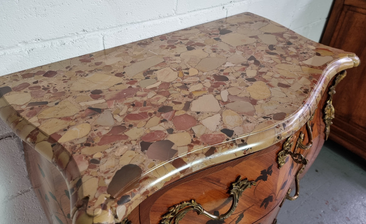 Charming petite French Louis XV style commode featuring two drawers, marquetry inlay, ormolu trim and marble Top. In good original detailed condition. Circa: 1930’s.