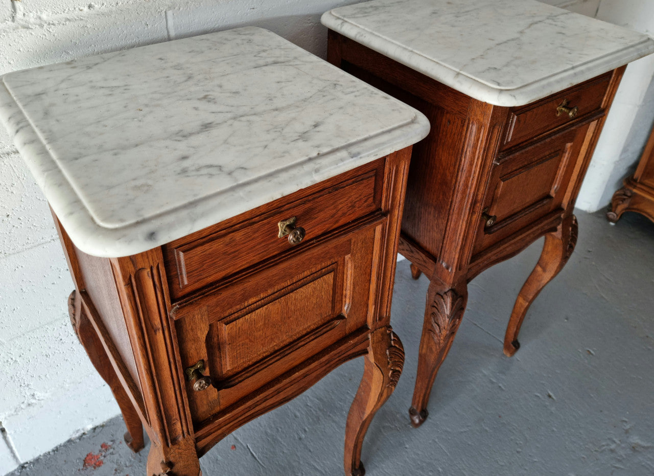Lovely pair of French Oak bedside cabinets with marble tops, cupboard and drawer. In good detailed original condition.