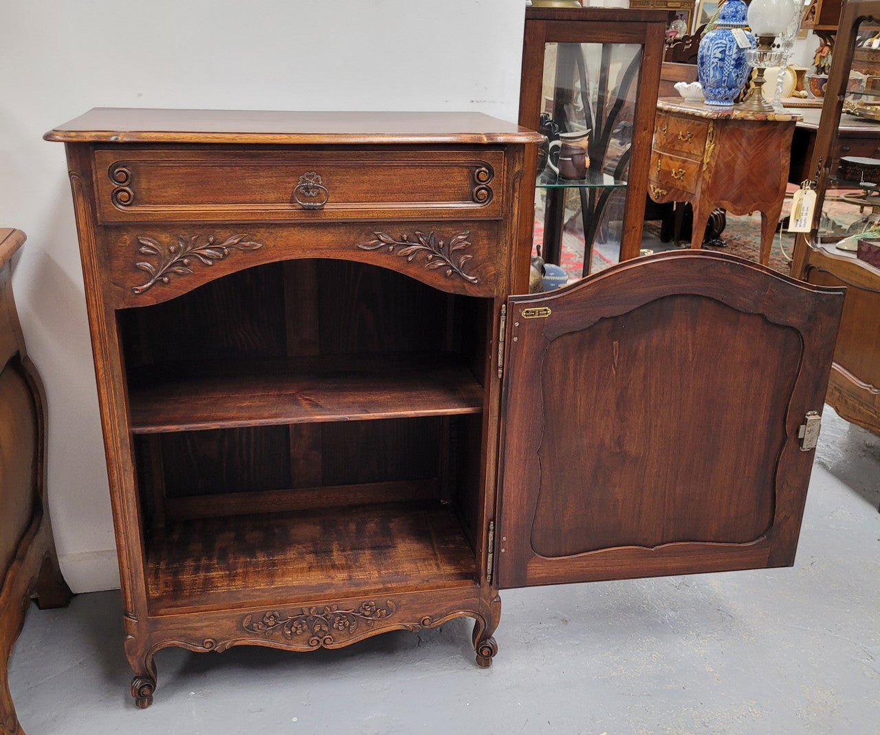 Louis 15th style walnut cupboard consisting of one drawer and two shelves. A pleasing unit with charming carvings. Circa: 1920's. In good original detailed condition.