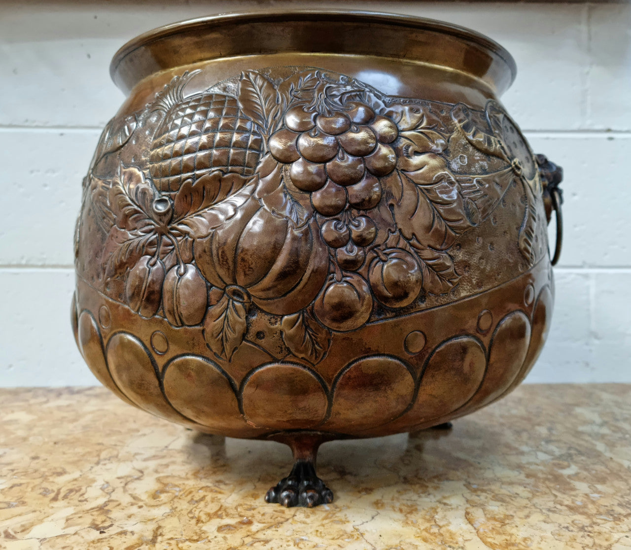 Antique large brass bronze coloured embossed Jardinière/planter with lovely details and lion heads for handles. It is in good original condition.