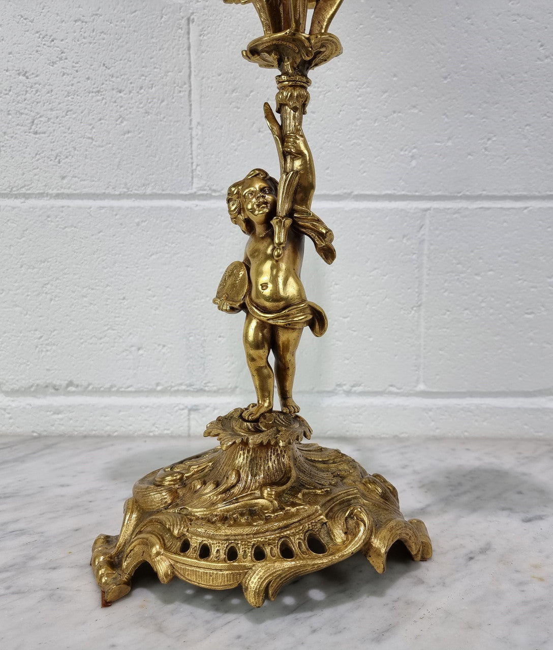 A pretty 19th Century French gilt bronze candelabra featuring a cherub. In good condition. Circa 1880.