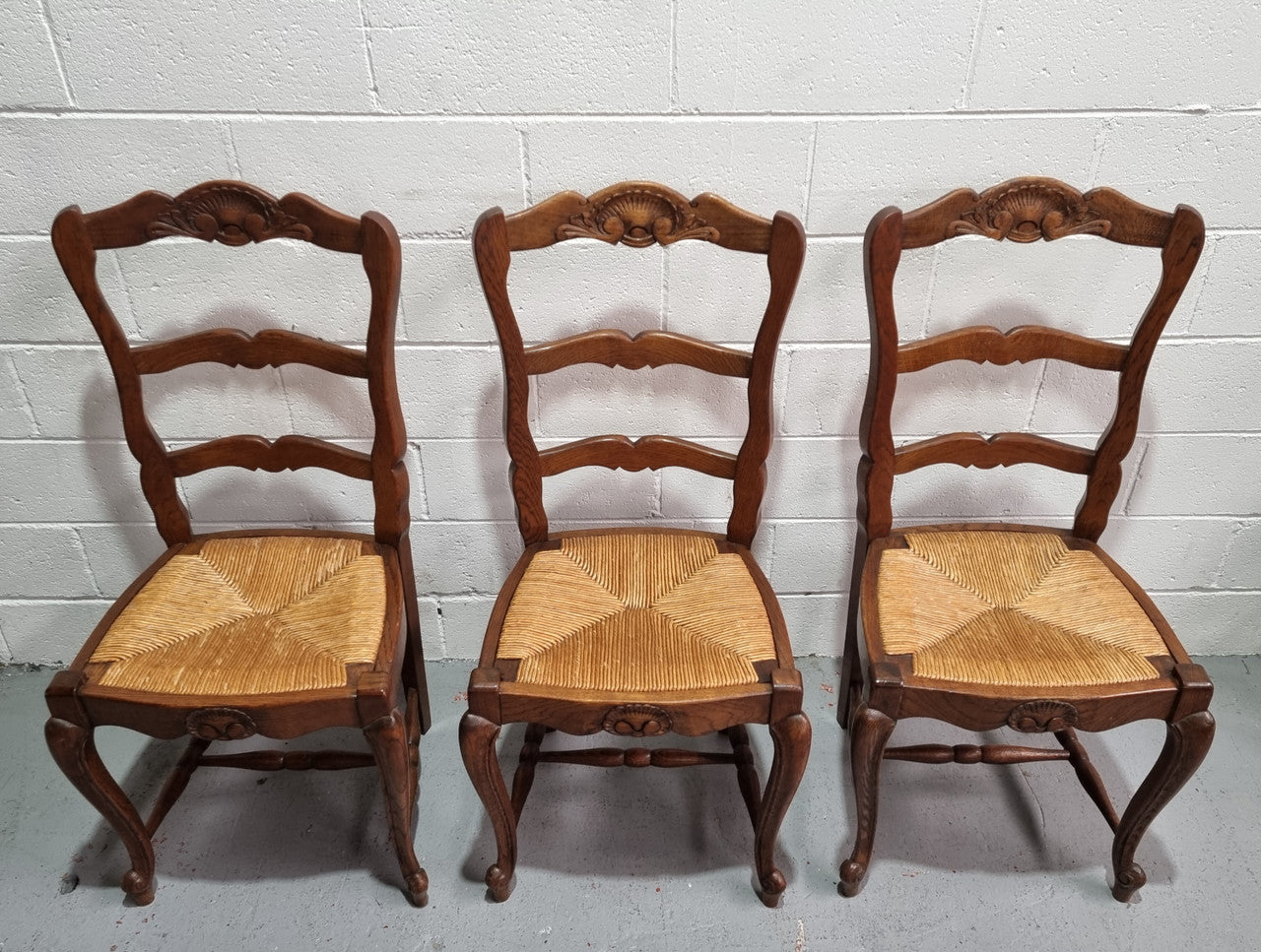 Lovely set of six French oak rush seated provincial dining chairs. They have been sourced from France and are in good detailed condition.