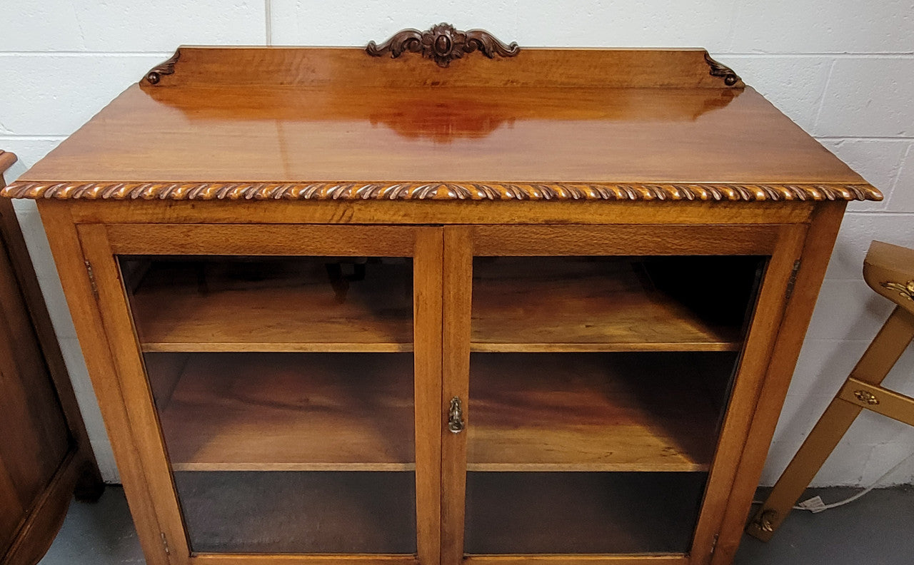 Chippendale style Mahogany two door bookcase. It has bevelled glass doors and two adjustable shelves. It has been sourced locally and is in good original detailed condition.