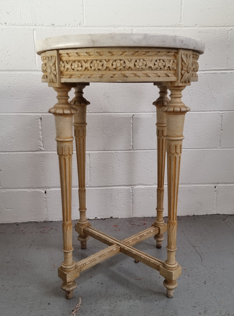 Louis XVI style round side table with original paint and a beautiful thick marble top. It is in good original detailed condition.
