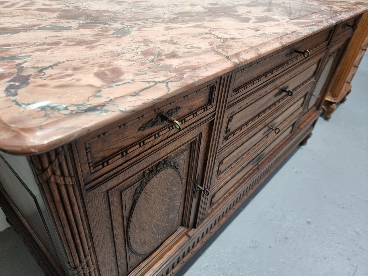 Absolutely beautiful French oak sideboard. It has 6 drawers and 2 cupboards for all your storage needs. There is a lovely coloured marble top and beautiful carving on the doors in good original detailed condition.