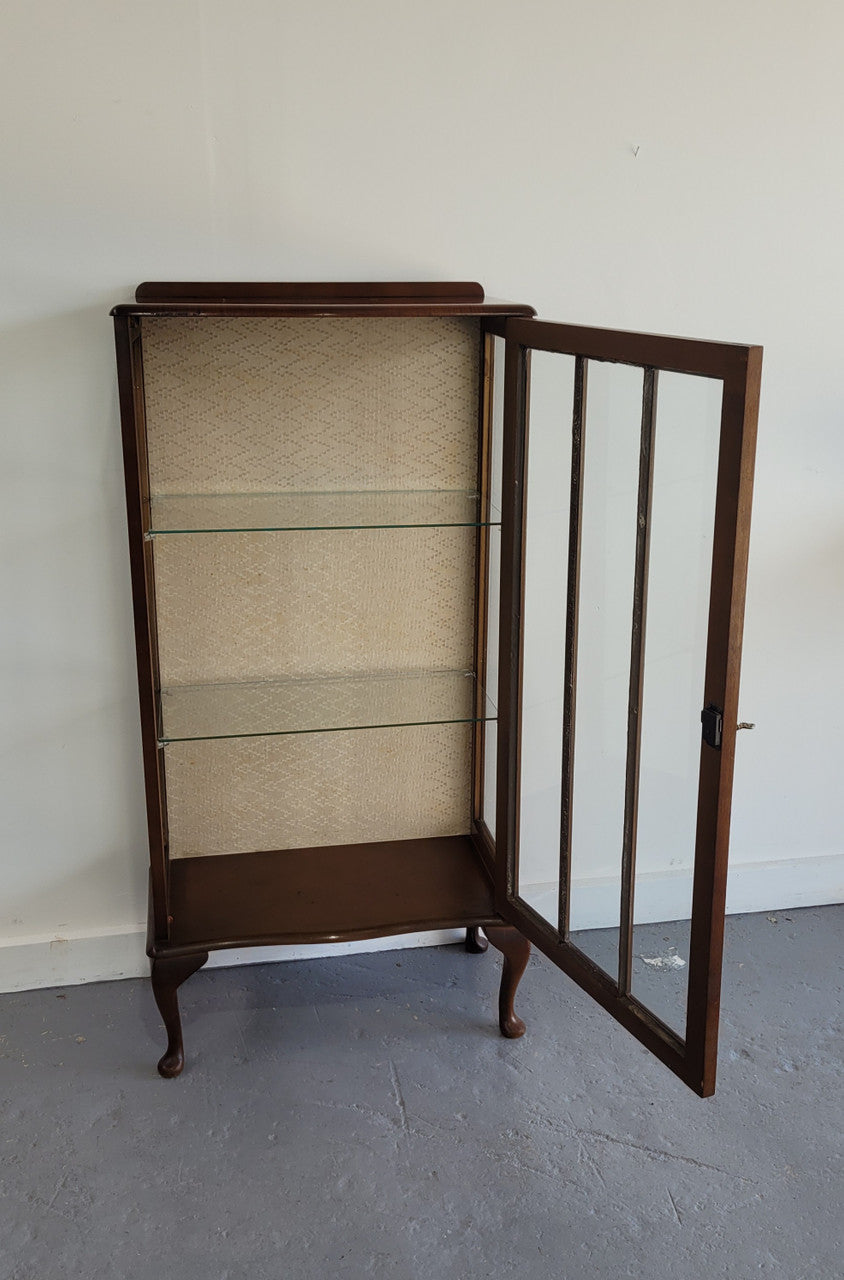 Petite single door Walnut display cabinet. Art Deco style with glass display door and two fixed shelves. In original condition.