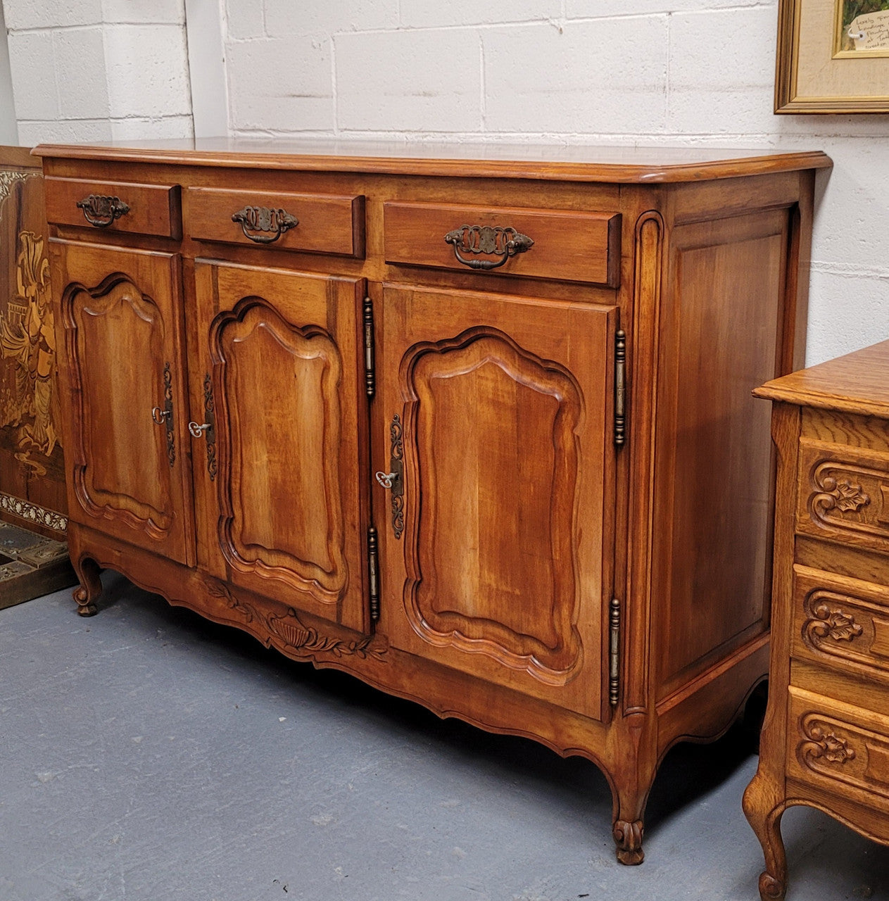 Beautiful French three door three drawer Louis XV style Cherrywood sideboard. It has a total of four adjustable shelves and comes with three keys. It has been sourced from France and is in good original detailed condition.