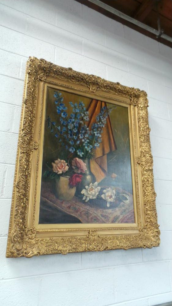 An Antique gilt-framed oil painting of floral still life. Housed in a double sweep gilt frame, signed and dated in good condition.