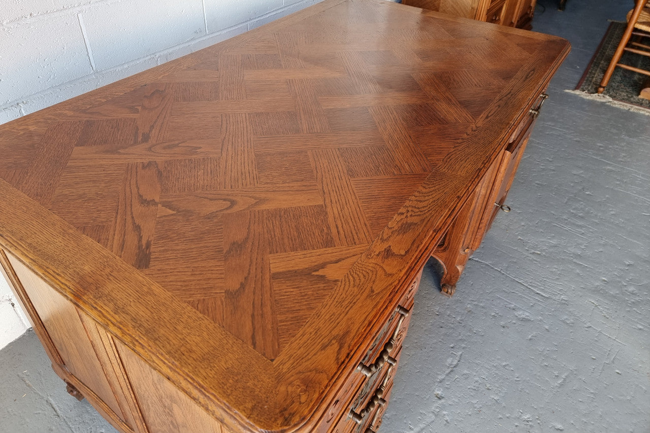 Beautifully carved french oak, faux partners desk with a lovely parquetry top and 6 drawers and 1 cupboard . In good original condition.