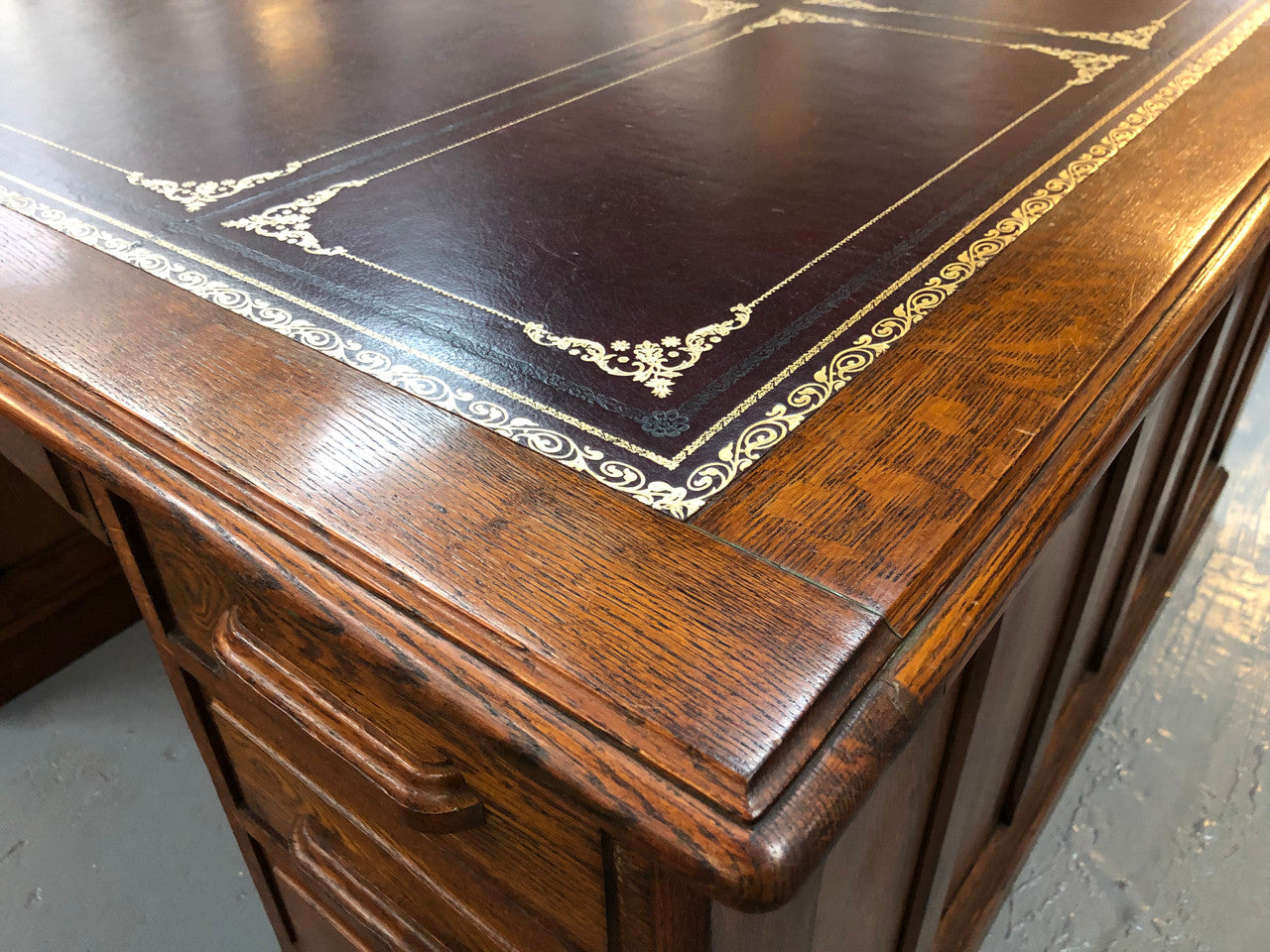 Lovely large English oak partners desk, with a beautiful burgundy tooled leather top. Plenty of storage space, both sides have 9 functioning drawers. It is in very good condition.