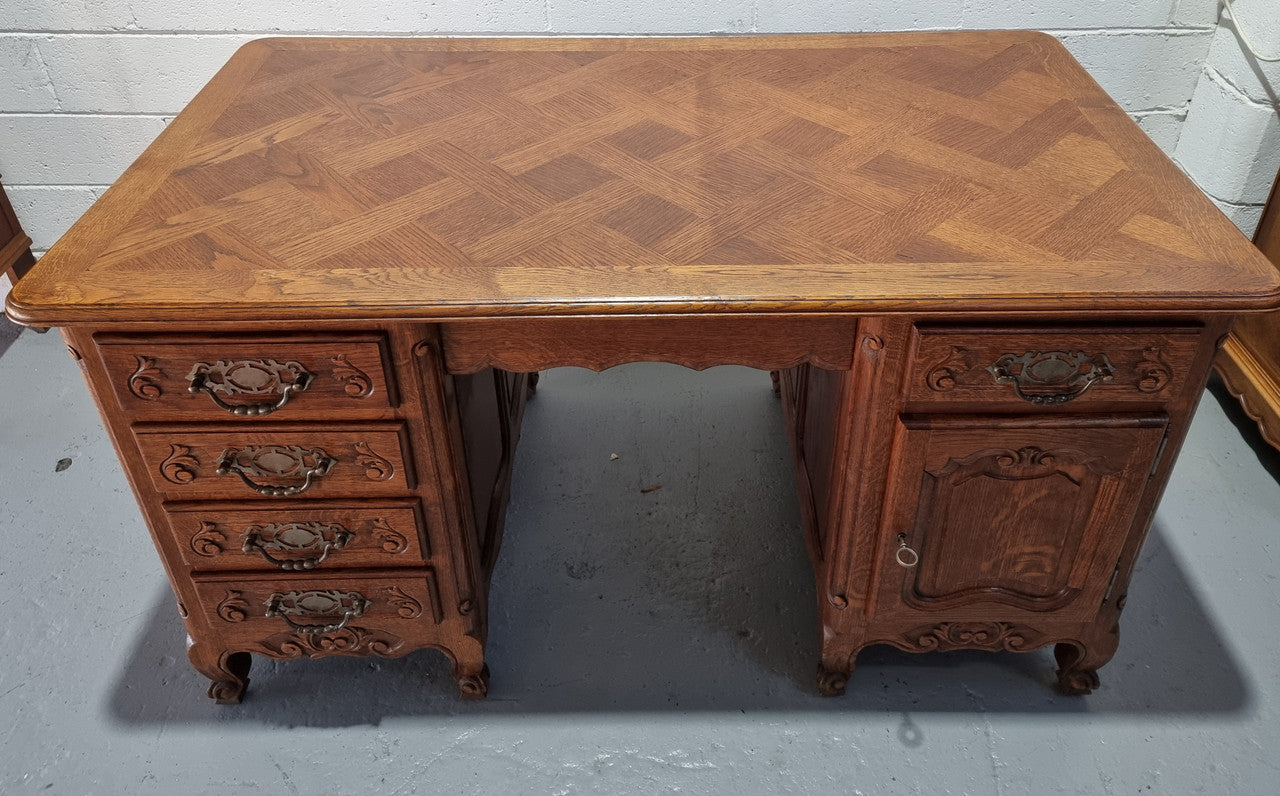 Beautifully carved french oak, faux partners desk with a lovely parquetry top and 6 drawers and 1 cupboard . In good original condition.