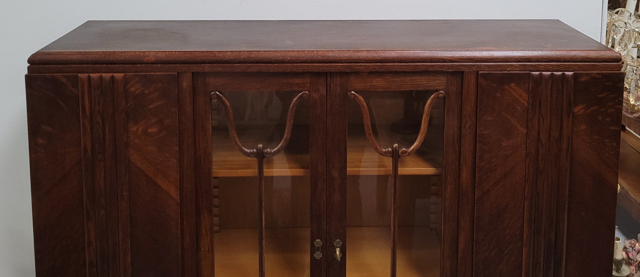 Stylish French Art Deco Oak bookcase with heaps of storage space and shelves. Middle section has two glass display doors. In good original detailed condition.