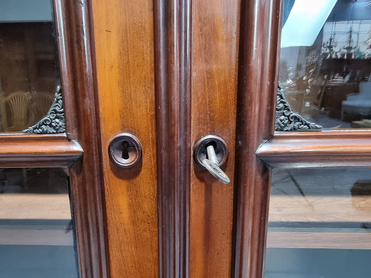Antique Mahogany two door Biedermeier style bookcase with four fully adjustable shelves and a drawer at the bottom. The two wooden finials at the top are easily removed for a different look of desired. In good original detailed condition.