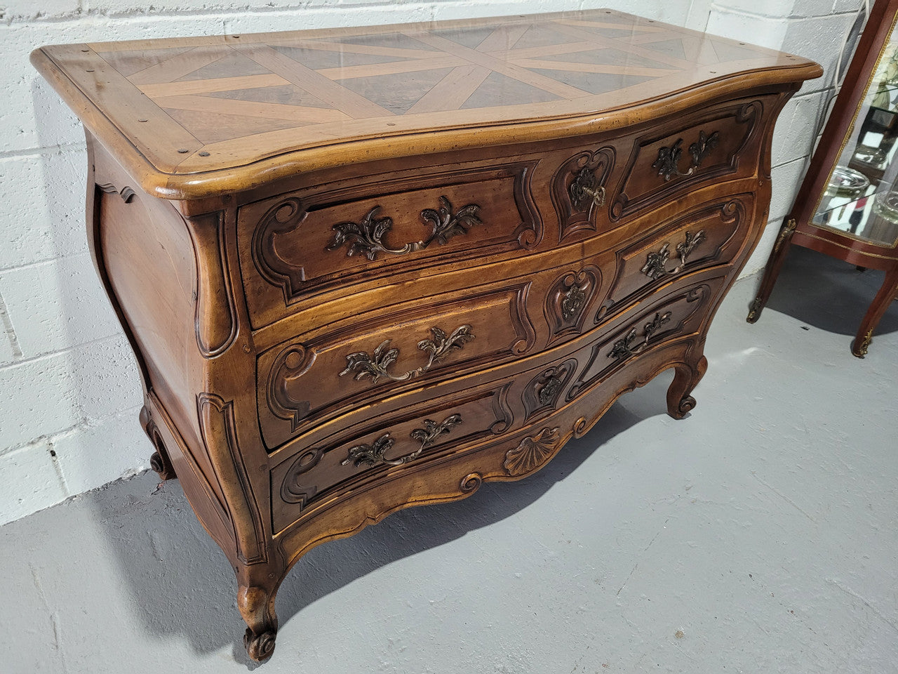 Impressive French Louis 15th style three drawer Commode featuring inlaid parquetry top and carving on drawers.