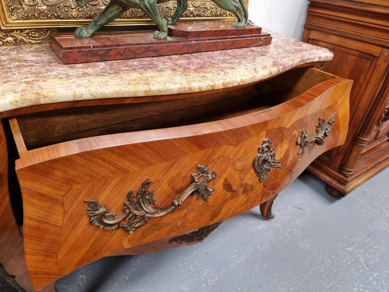 Attractive French Louis XV style walnut two drawer marquetry inlaid commode. With impressive ormolu handles and trims and shaped marble top. It has been sourced from France and is in good original detailed condition.