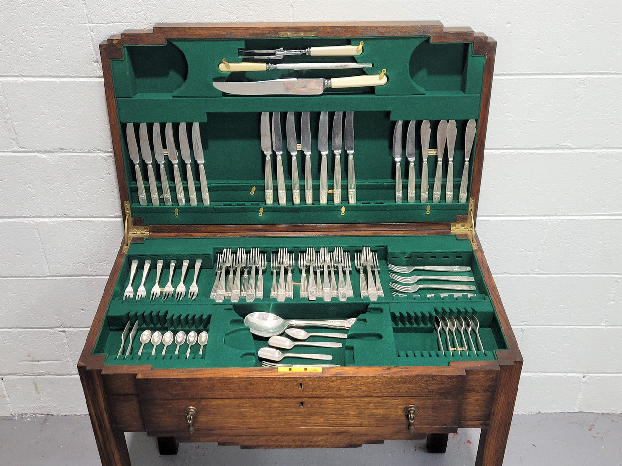 English Oak beautifully fitted cutlery table with a lift up top and drawer. Contains extensive silver plate part cutlery service by Elkington. In good original condition.