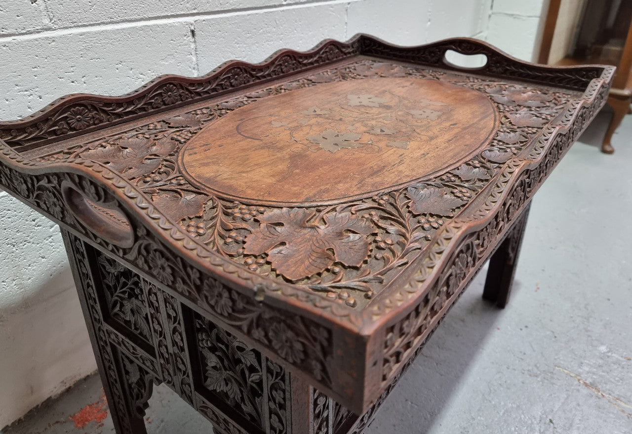 Anglo Indian folding occasional table with lift-up tray top. The tray has brass inlay and ornate carvings. The bottom of the table folds down and it is in good original condition.