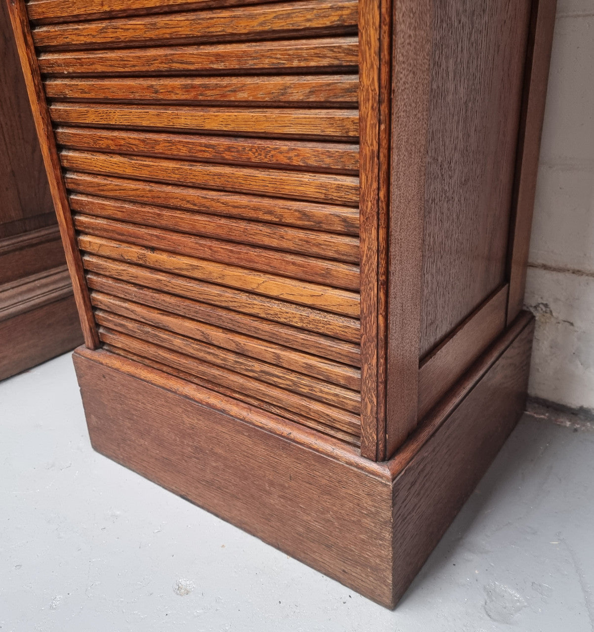 Antique Edwardian roll top Tambour file cabinet desk. This practical antique tambour front filing cabinet dates around 1900 in the Edwardian period and is constructed from Oak. This antique cabinet has an adjustable writing slope, above a tambour front with key and working lock. It has been sourced locally and is in good original detailed condition.